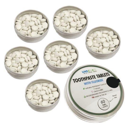 Multiple containers of toothpaste tablets with a branded container labeled 'Toothpaste Tablets with Fluoride' on a white background.