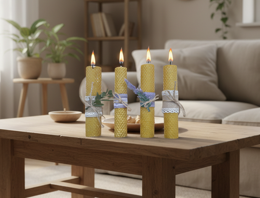 Four lit candles wrapped in rustic materials on a white background
