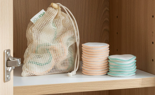 Mesh bag with reusable cotton pads on a white background