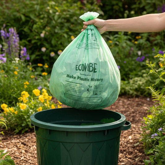 Green ECOVibe trash bag held by a hand on a white background